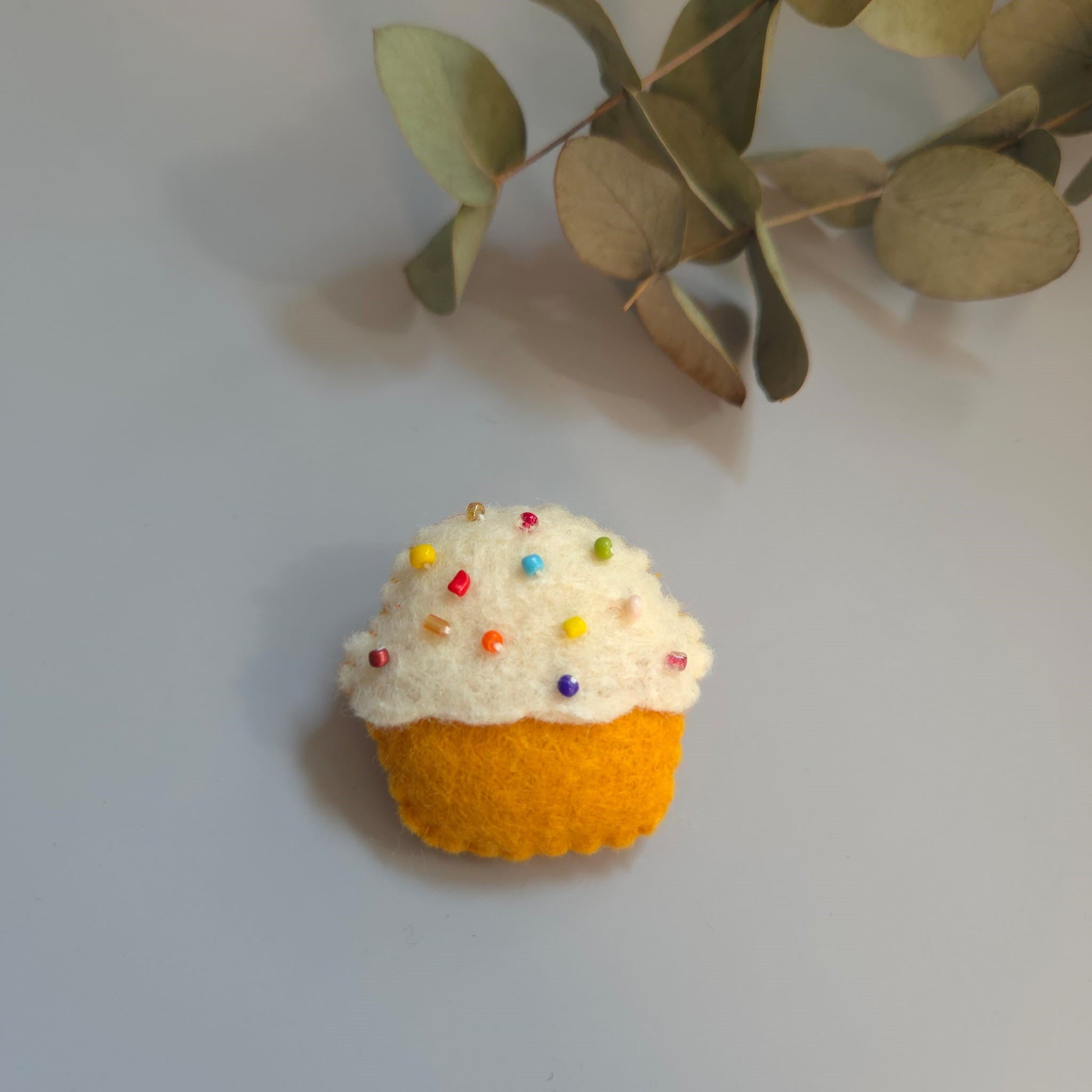 Broșă handmade din fetru în formă de brioșă