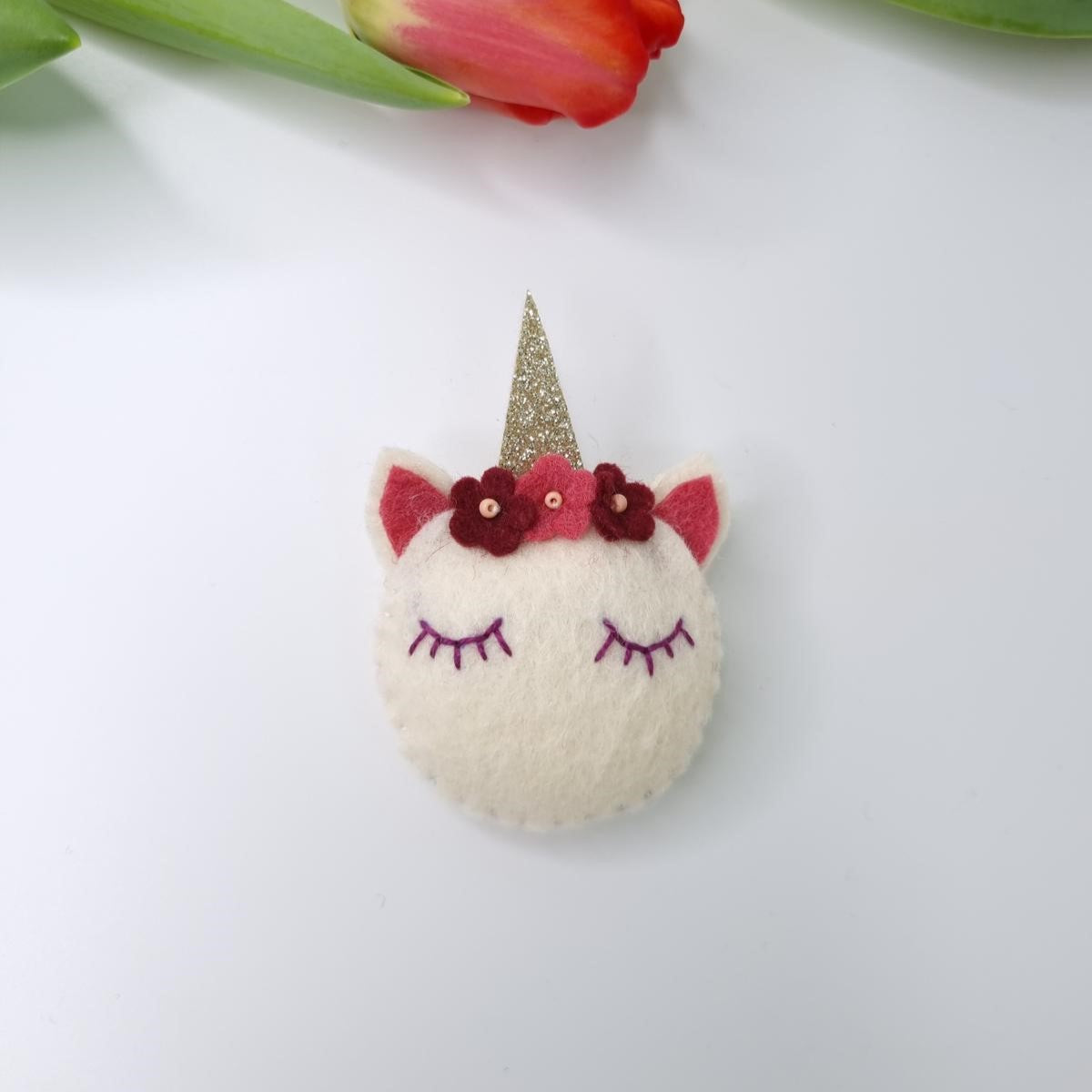 Broșă unicorn handmade din fetru cu corn auriu și flori decorative